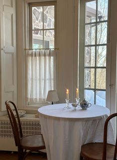 two chairs and a table with candles on it