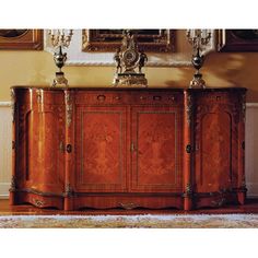 an ornately decorated sideboard stands in front of paintings