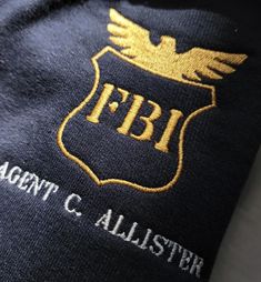 an emblem on the back of a jacket that says fbi agent c allister