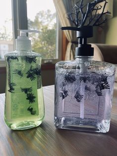 two soap dispensers sitting on top of a wooden table next to a window