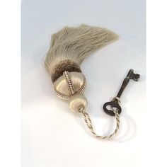 an old fashioned shaving brush with a key on the side and a cord attached to it