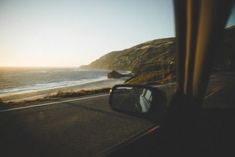 the view from inside a car looking out at the beach and ocean in the distance