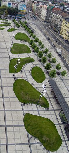 an aerial view of a city with lots of green grass