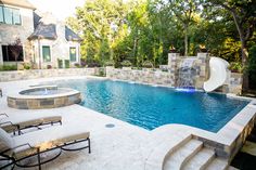 a pool with a slide in the middle of it and some lawn chairs around it