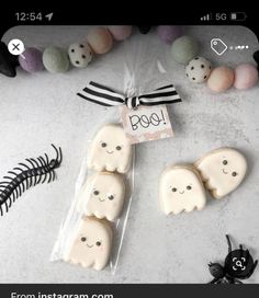 some cookies that are sitting on a table next to other treats and decorations with the word boo spelled out