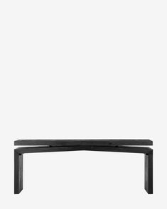 a black bench sitting in front of a white wall