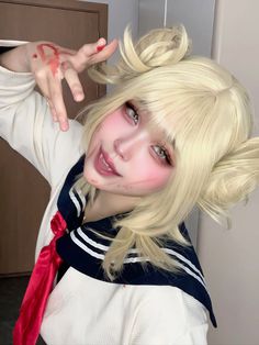 a woman with blonde hair wearing a white shirt and red tie posing for the camera