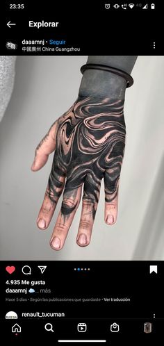 a hand with black and grey designs on it, in the middle of an instagramtion