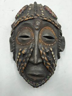 an african mask is hanging on the wall