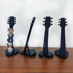 three guitars are lined up on top of each other, one is black and the other is blue