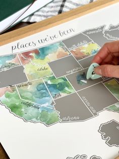 a person is painting the states on a map with watercolors and paper scissors