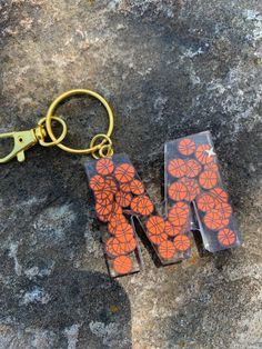 two pieces of glass with an orange flower design on them sitting on top of a rock