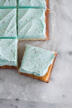 four pieces of cake sitting on top of a piece of parchment paper with frosting