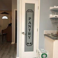 a pantry door with the word pantry painted on it in black and white, next to a kitchen counter