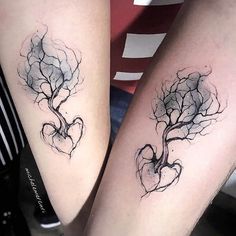 two people with tattoos on their legs, one has a tree and the other has a heart