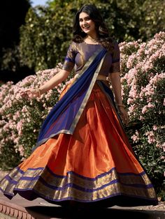 Embrace the vibrant elegance of our orange Kanchipuram silk lehenga, exquisitely paired with a blue Kanchipuram silk choli and a matching blue georgette dupatta. This ensemble showcases the rich heritage and craftsmanship of traditional Indian attire, featuring intricate zari weaving work that exudes luxury and sophistication. The orange lehenga, with its striking color and detailed design, is the perfect choice for making a bold statement at any grand event.
The lehenga offers a generous 3.70-m Kanchipuram Half Saree, South Indian Lehenga, Ceremonial Wedding, South Indian Wedding Saree, Orange Lehenga, Stylish Kurtis Design, Simple Lehenga, Half Saree Lehenga, Sabyasachi Lehenga