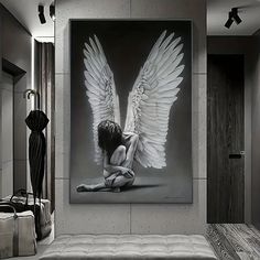 a black and white photo of a woman with angel wings on her body sitting in front of a mirror