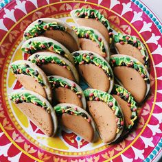 there are many cookies on the plate with icing and sprinkles around them