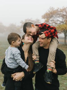 a man, woman and child are posing for a photo in the foggy field