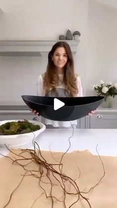 a woman standing in front of a table with two bowls of food on top of it