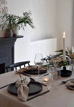 a dining table with place settings and candles