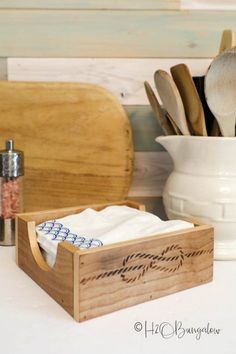 a wooden box filled with utensils on top of a counter