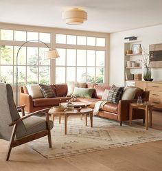 a living room filled with furniture and large windows