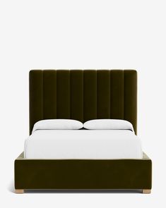 a bed with a green headboard and white sheets