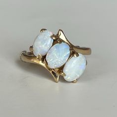 Vintage 14K Three Stone Opal Ring, 3.0 grams, Size 3, October Birthstone  Beautiful triple oval cut Opal ring in 14K yellow gold setting and spacer. Actual ring size may be larger. Weight: 3.0 grams Size: 3 Stone: Opal Color Stone: White Transparent Size Stone: ca. 6mm x 4mm Markings: 14K, symbol Band Width: 1.8mm Tested: Presidium Gemtester ll, Niton DXL Thermo Scientific Metal Analyzer, This was weighed on an Ohaus Scout® Jewelry Scale (testing performed by 3rd party) Condition: Very good preo Three Stone Oval Cabochon Rings For Anniversary, Yellow Gold Three Stone Oval Birthstone Ring, Oval Three Stone Opal Ring, Gold Oval Three Stone Birthstone Ring, Oval Three Stone Opal Ring For Anniversary, Gold Oval Three Stone Opal Ring, Gold Oval Opal Ring With Three Stones, Gold Three Stone Oval Rings, Yellow Gold Three Stone Opal Ring For Anniversary