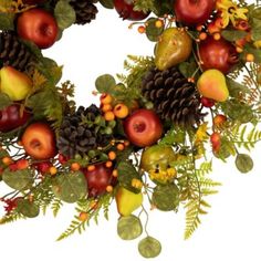 a wreath made up of apples, pears and pine cones with leaves on it