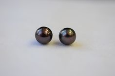 The size of the round Japanese Akoya black pearls are approximately 7x6.5mm with high luster. The color is black to dark grey, but has a pinkish purple overtone. They are set in 14K yellow gold post and backing. All inventory is in stock and ready to be shipped once we have received payment. You will receive black pearls are close as to the ones photographed. For more information, Like us on Facebook, follow us on Instagram or visit our website www.ikedapearl.com If you have any questions or inq Classic Tahitian Pearl Earrings For Gift, Classic Tahitian Pearl Earrings As Gift, Tahitian Pearl Round Anniversary Earrings, Elegant Black Round Pearl Earrings, Black Round Pearl Earrings For Formal Occasions, Classic Black Pearl Earrings, Elegant Black Tahitian Pearl Earrings, Black Pearl Earrings As A Gift, Gift Black Round Pearl Earrings