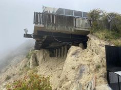 a cliff side house on top of a hill with stairs leading up to the roof