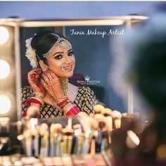 a woman is getting her make up done in front of a mirror with lights on it