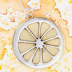 Ring in warmer weather with this cute summertime pendant -- a lemon slice! Handcrafted by artisans in Mexico, the sweet citrus piece features a mix of shining metals and supports the skilled jewelry artists that made it. Sterling silver & brass Pendant: 1.25" L x 0.6" W Optional 18" L sterling chain Handmade in & fairly traded from Mexico Nickel-free Yellow Round Pendant Jewelry, Paw Print Jewelry, Ribbon Jewelry, Fair Trade Jewelry, Sweet Citrus, Printed Jewelry, Craft Markets, Lemon Slice, Dining Accessories