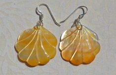 This beautiful earrings feature a carved yellow Mother of Pearl Scallop Shell. . The iridescence of the Mother of Pearl is really amazing. Depending on the light source they will radiate colors varying from yellows to creamy whites with flashes of pinks. The shells are then polished to a high gross to reveal the beauty of their natural pattern. The perfect way to complete your beach outfit and everyday wear. DETAILS - Shell types : Mother of Pearl - Material: Sterling Silver Ear Wire and Jump Ri Shell Types, Jewelry Island, Island Jewelry, Hawaiian Jewelry, Beach Earrings, Scallop Shell, Cute Gift Boxes, Scallop Shells, Dangling Earrings