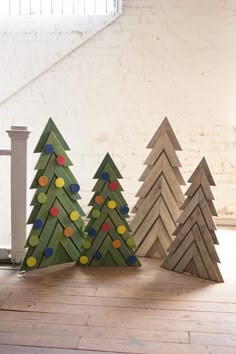 three wooden christmas trees sitting next to each other