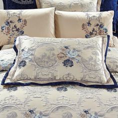 the comforter is made up with blue and white flowers on it, along with matching pillows