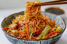 a close up of a bowl of noodles with chopsticks