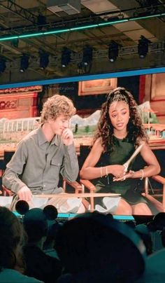 two people sitting in front of a large screen