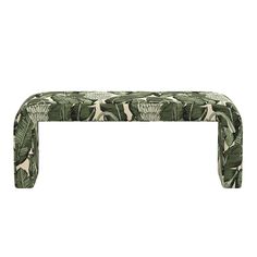 an upholstered bench with green leaves on it