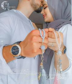 a man and woman are dressed in white with jewelry on their hands while holding each other's hand