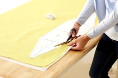 a person cutting fabric with scissors on a table