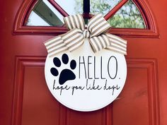 a door hanger that says hello, hope you like hugs with a paw print on it