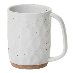 a white coffee mug with brown speckles on the outside and inside, sitting in front of a white background