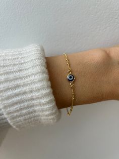 Brush away negative energy and jealous prying eyes with this dainty evil eye bracelet! D E T A I L S *It features a gold filled evil eye charm (12 x 6.5mm) in traditional blue. *on a dainty 18k yellow gold filled satellite chain.  *Gold filled is a wonderful alternative to solid gold and unlike gold plating does not rub off. *It closes with a hall marked gold filled spring ring clasp. *Choose the length from the drop down menu. Use the length guide as a reference. *Bracelet comes with an explana Greek Evil Eye Bracelet, Evil Eye Charm Bracelet, Gold Bracelet With Charms, Everyday Yellow Gold Evil Eye Bracelets, Evil Eye Bracelet For Everyday Wear, Dainty Evil Eye Bracelet For Everyday, Dainty Yellow Gold Bracelet With Evil Eye Detail, Dainty Yellow Gold Bracelet With Evil Eye, Elegant Everyday Evil Eye Bracelet