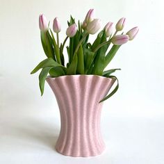 there is a pink vase with flowers in it