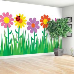 a living room with flowers painted on the wall and a potted plant next to it