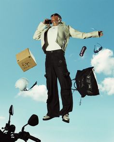 a man standing on top of a motorcycle next to a bag and some other items