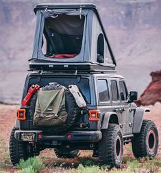 the jeep is parked in the desert with its roof open