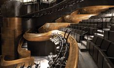 an empty auditorium with wooden seats and railings